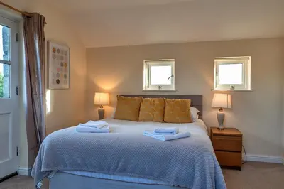 a bedroom with a bed with two towels on it at Finest Retreats - Trennal Barn in Germoe