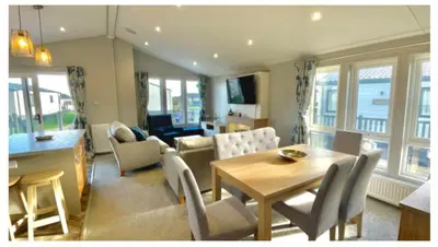 a living room with a table and chairs and a dining room at The Retreat Lodge in Newquay