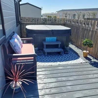 a backyard with a bench and a hot tub at The Retreat Lodge in Newquay