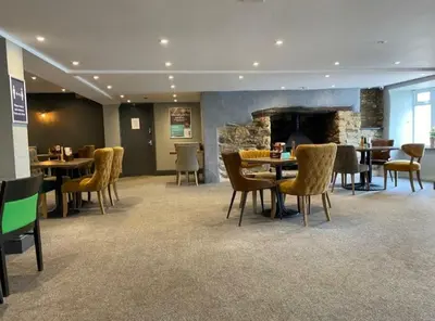 a dining room with tables and chairs and a fireplace at The Retreat Lodge in Newquay