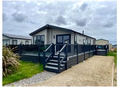 a tiny house with a blue fence and stairs at The Retreat Lodge in Newquay