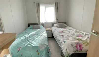two beds in a small room with a window at The Retreat Lodge in Newquay