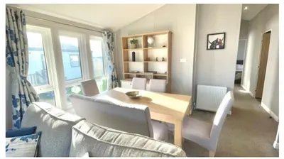 a dining room table with chairs and a laptop on it at The Retreat Lodge in Newquay