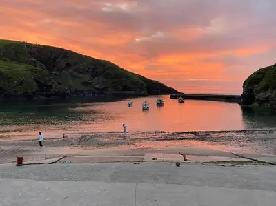 a group of boats in a river at sunset at Moll's Yard in Port Isaac