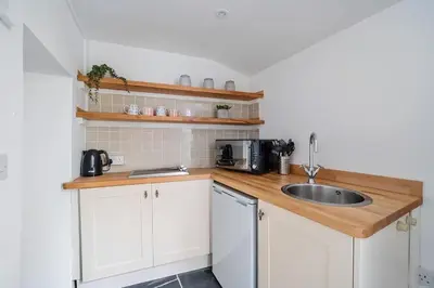 a small kitchen with a sink and a microwave at Moll's Yard in Port Isaac