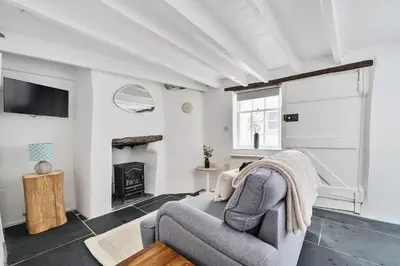 a living room with a couch and a fireplace at Moll's Yard in Port Isaac