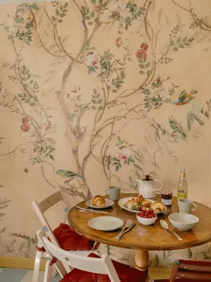 a table with food on it with a floral wall at Rose Garden Maisonette in Falmouth