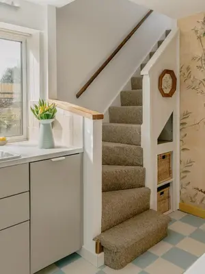 a staircase in a home with white walls and carpeted floors at Rose Garden Maisonette in Falmouth