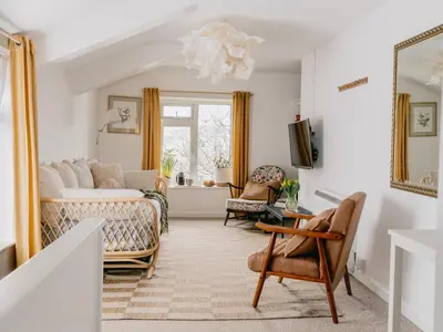 a living room with a bed and a couch at Rose Garden Maisonette in Falmouth