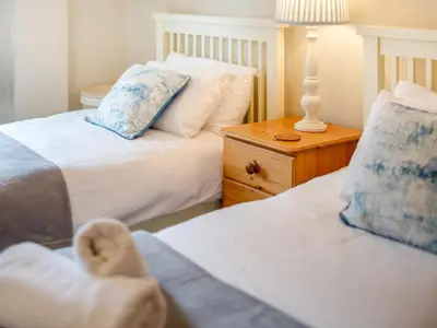 a bedroom with two beds and a table with a lamp at 3 Bed in St. Austell oc-95623 in Gorran Haven