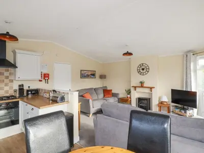 a kitchen and living room with a couch and a table at Laurel Lodge in Tintagel