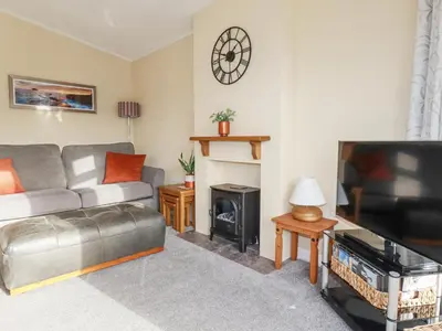 a living room with a couch and a flat screen tv at Laurel Lodge in Tintagel