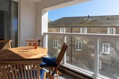 a dining room with a table and a large window at 3 St Nicholas Court in St Ives