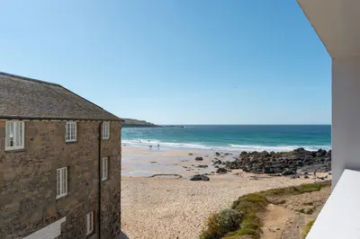 a view of the beach from the balcony of a building at 3 St Nicholas Court in St Ives