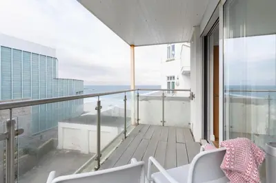 a balcony with chairs and a view of the ocean at Four Seawinds in St Ives
