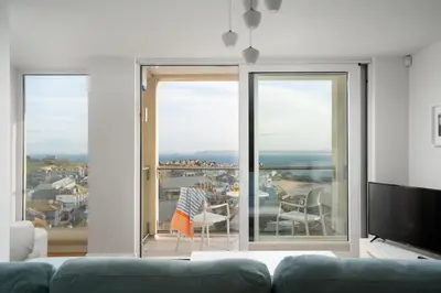 a living room with a couch and a large window at Four Seawinds in St Ives