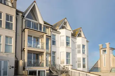 a row of white apartment buildings with balconies at Four Seawinds in St Ives