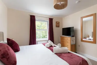 a bedroom with a large bed and a television at The Oystercatcher in St Ives