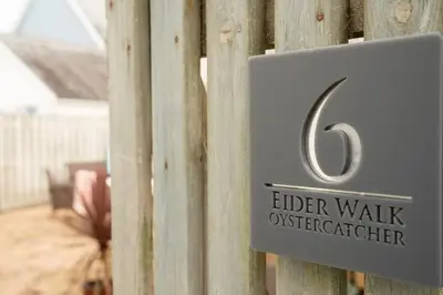a sign that says elder walk investigator on a fence at The Oystercatcher in St Ives