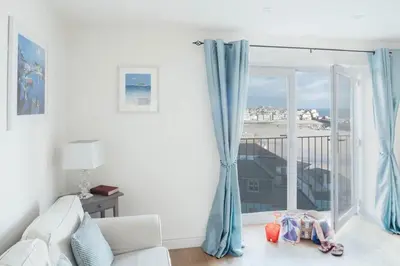 a living room with a couch and a large window at 10 Fernlea Court in St Ives