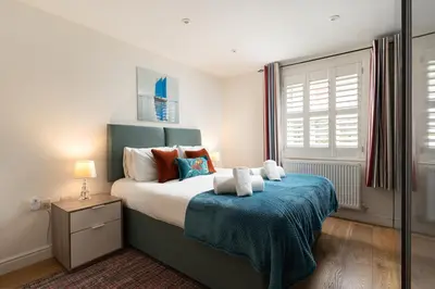 a bedroom with a bed with a blue blanket at 10 Fernlea Court in St Ives