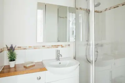 a white bathroom with a sink and a shower at 10 Fernlea Court in St Ives