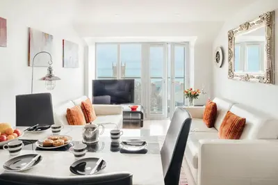 a living room with a white couch and a table at 10 Sunday School Court in St Ives