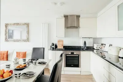a kitchen with white cabinets and a table with fruit on it at 10 Sunday School Court in St Ives