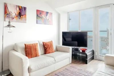 a living room with a white couch and a flat screen tv at 10 Sunday School Court in St Ives