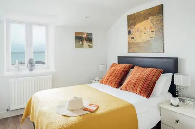 a bedroom with a bed with a hat on it at 10 Sunday School Court in St Ives