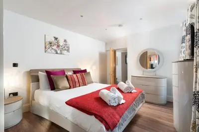 a bedroom with a bed with towels on a red blanket at 3 The Elms in St Ives
