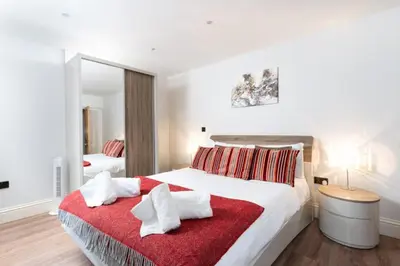 a bedroom with a large bed with a red blanket at 3 The Elms in St Ives