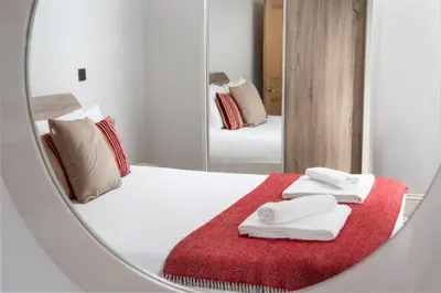 a mirror reflection of a bed with towels on it at 3 The Elms in St Ives