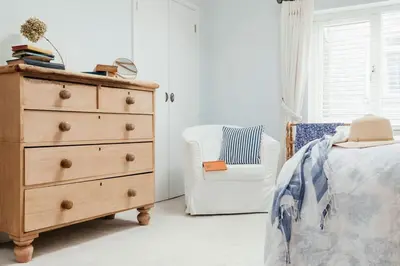 a bedroom with a dresser and a chair next to a bed at Ponckle's Place in St Ives