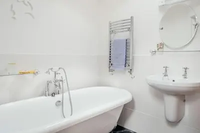 a white bathroom with a tub and a sink at Ponckle's Place in St Ives