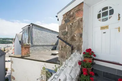 a building with a white door and some flowers at Ponckle's Place in St Ives