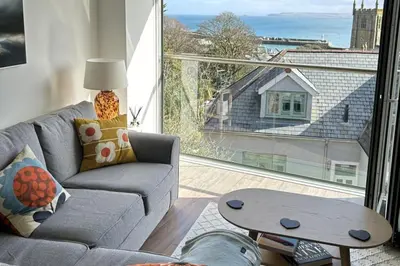 a living room with a couch and a large window at 11 Sunday School Court in St Ives