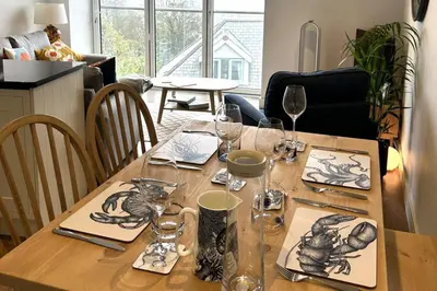 a wooden table with wine glasses and plates on it at 11 Sunday School Court in St Ives