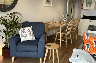 a living room with a blue chair and a table at 11 Sunday School Court in St Ives