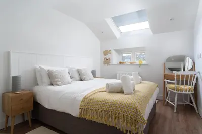 a bedroom with a large bed and a window at 11 Sunday School Court in St Ives