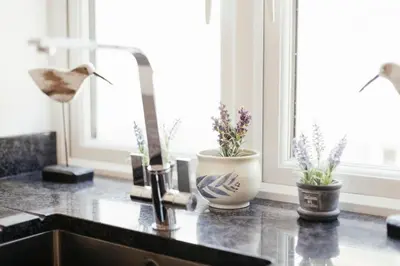 a kitchen counter with a sink with flowers on it at 2 The Elms in St Ives