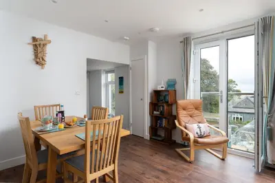 a dining room with a table and chairs and a window at 1 The Elms in St Ives