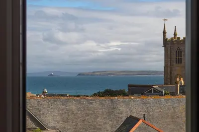 a view of a church and the ocean from a window at 1 The Elms in St Ives