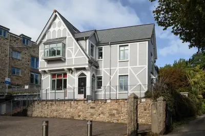 a white and gray house with a stone wall at 1 The Elms in St Ives