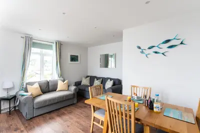 a living room with a couch and a table at 1 The Elms in St Ives