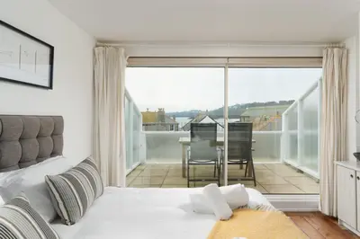a bedroom with a bed and a balcony at 22 Piazza in St Ives