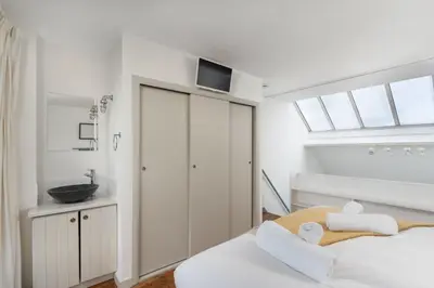 a white bedroom with a bed and a sink at 22 Piazza in St Ives