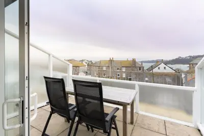 a balcony with a table and chairs and a view at 22 Piazza in St Ives