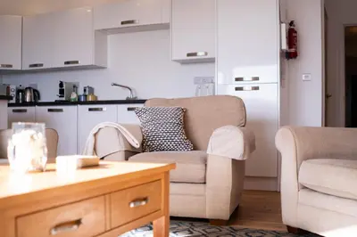 a living room with two chairs and a table at The Beach in Praa Sands