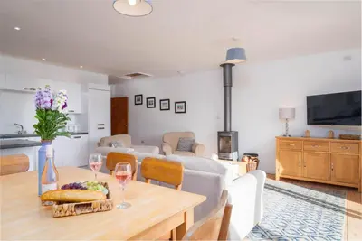 a living room with a couch and a table with wine glasses at The Beach in Praa Sands